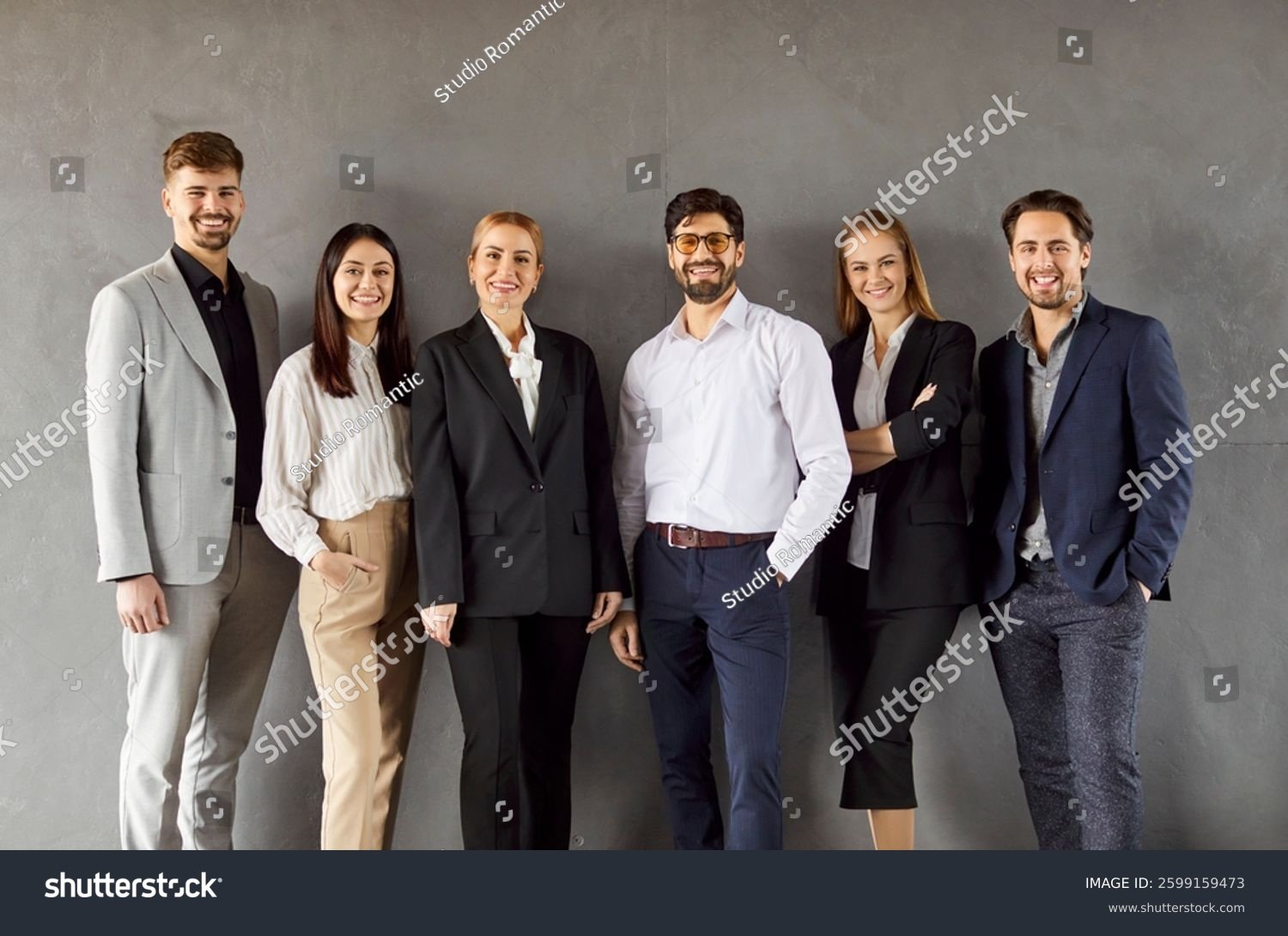 stock-photo-confident-leader-and-company-staff-members-standing-for-corporate-photo-posing-successful-office-2599159473